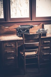 An image of an old typewriter on a desk for the AltWriters Ghostwriting Services page.